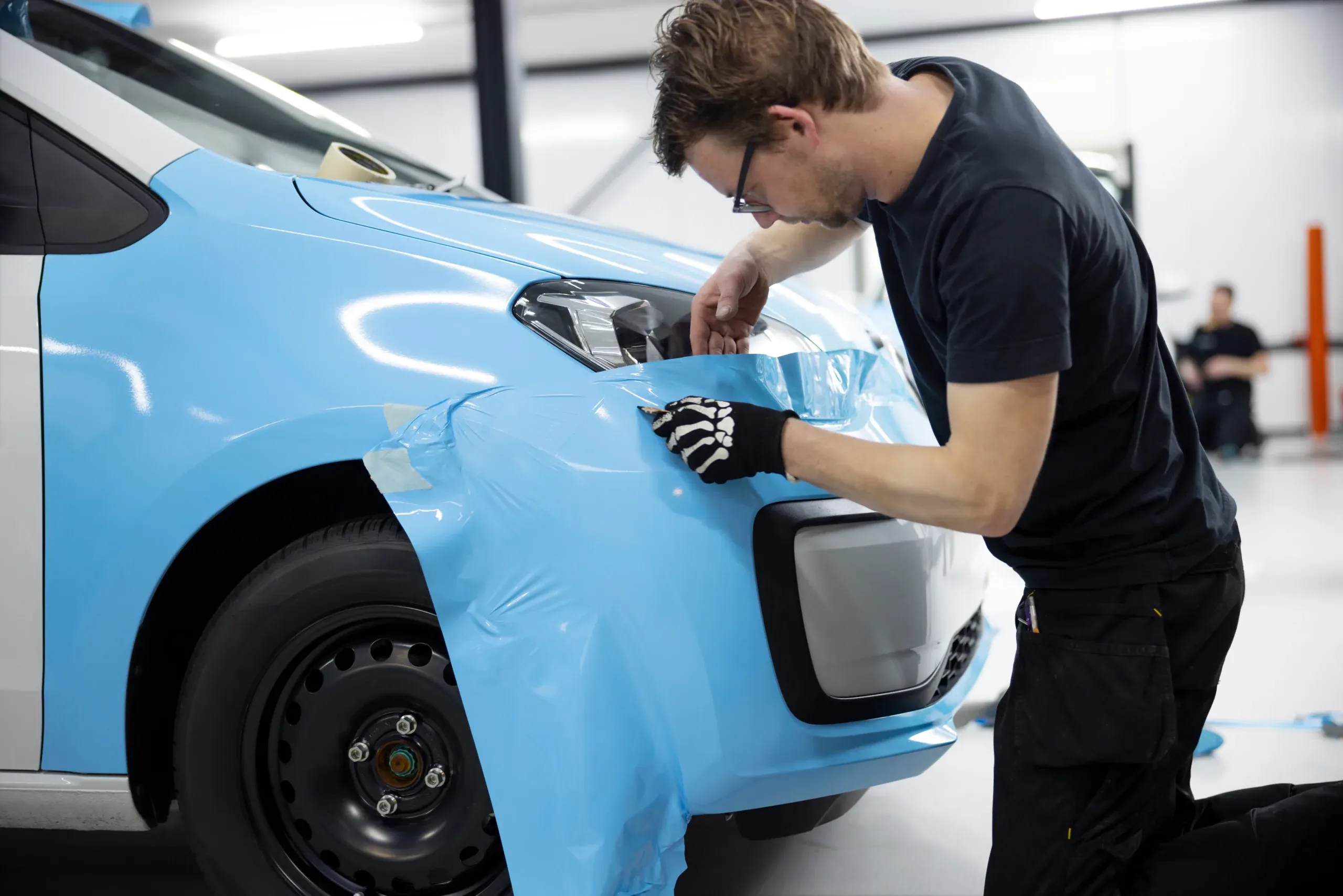 professional-wrapping-car-with-blue-cover-medium-shot